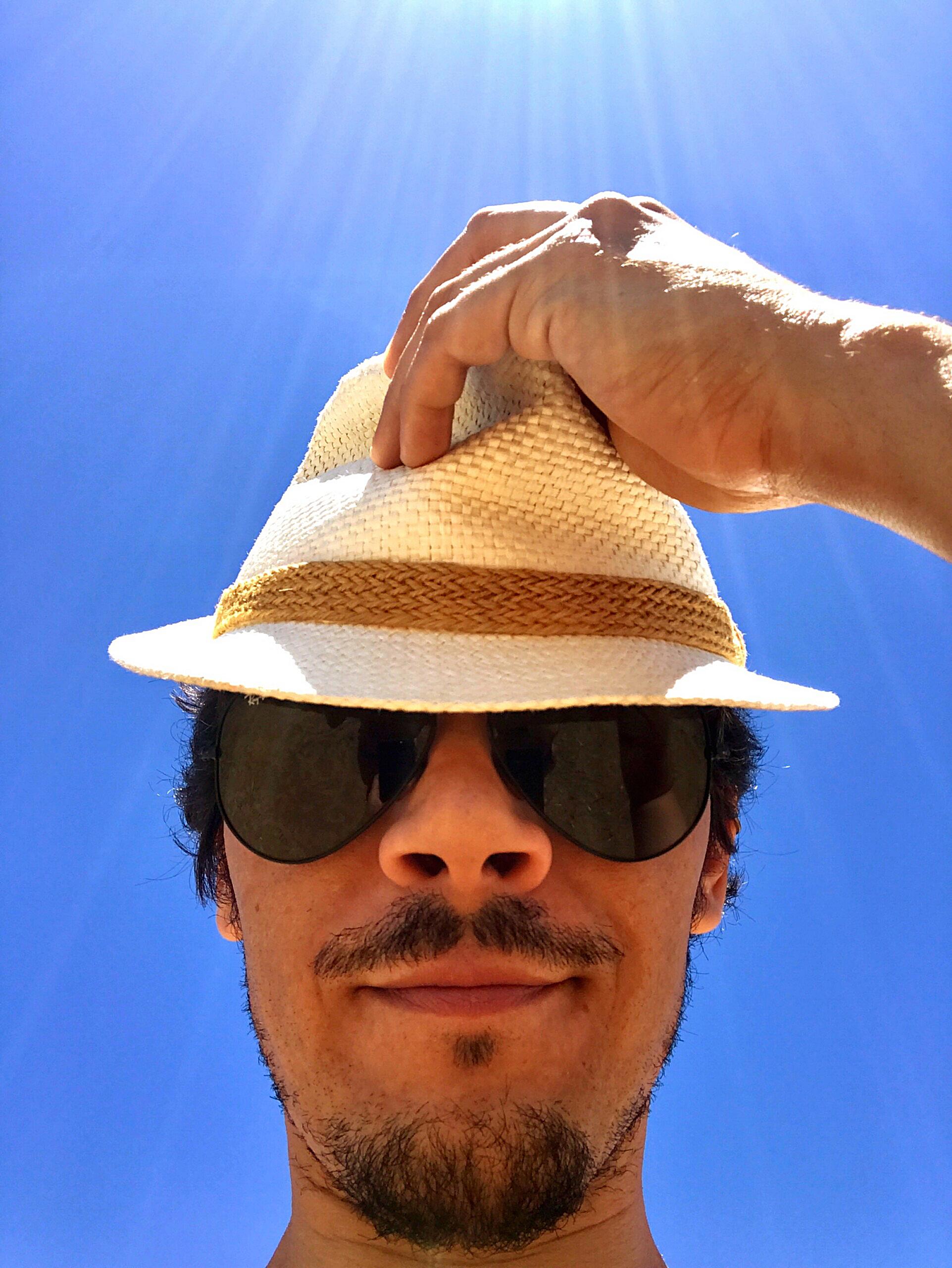 portrait-man-wearing-sunglasses-hat-against-clear-blue-sky-scaled-concentrate